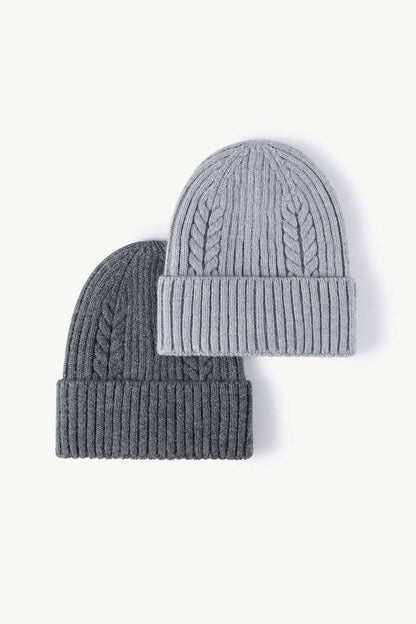 Dark gray and gray Cable-Knit Cuff Beanies displayed together, offering a classic and versatile color combination with textured knit patterns and fold-over cuffs for a cozy, stylish winter accessory.